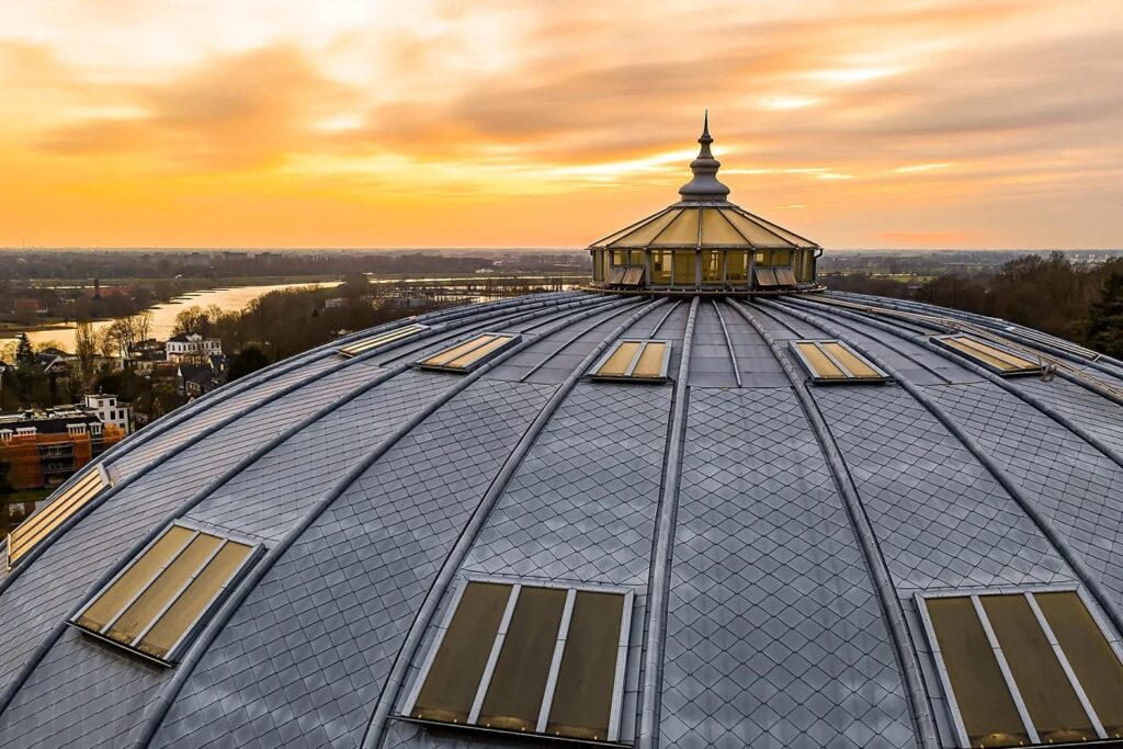 De Koepel van de koepelgevangenis in Arnhem, met op de achtergrond de Rijn en een zonsondergang